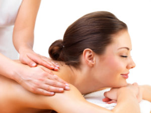 Young woman getting massage from female hands